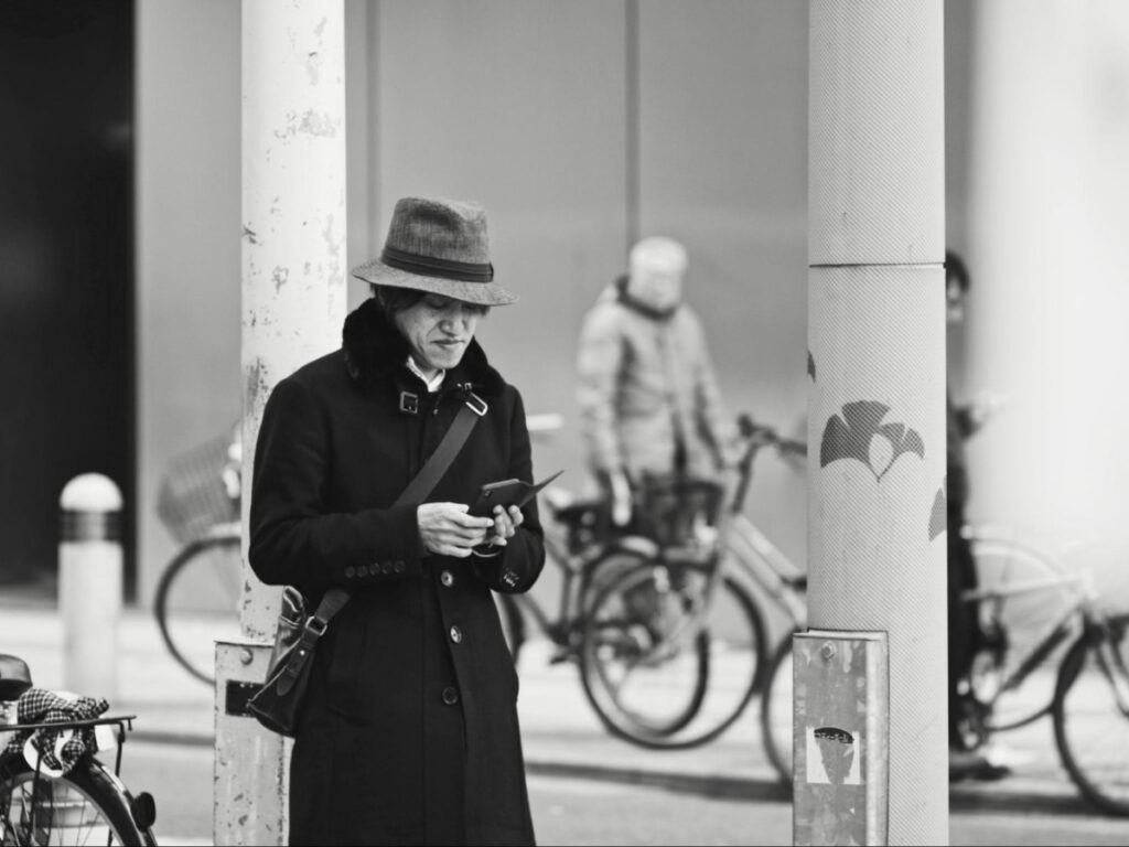 A man checking his phone near the Osaka  Airport
