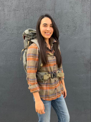 The author, Abigail Bliss smiling for a photo while carrying the Salkan Carry-On Backpack on her back