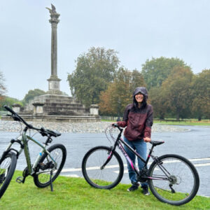 The author Abigail Bliss wearing a rain jacket while holding her bicycle