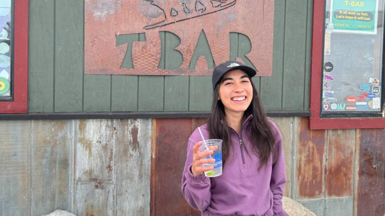 The author Abigail Bliss, holding a drink outside T Bar