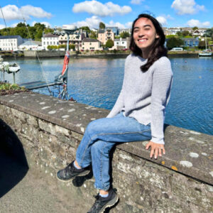 The author Abigail Bliss sitting with an overlooking view of the lake in the background