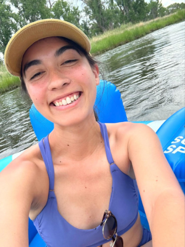 Travel Lemming author Abigail Bliss, smiling for a photo while tubing on the South Platte