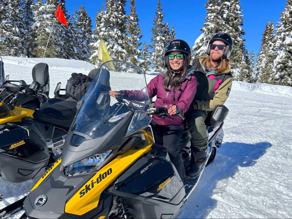 Travel Lemming Editor Abigail Bliss and her husband, riding on the snowmobile