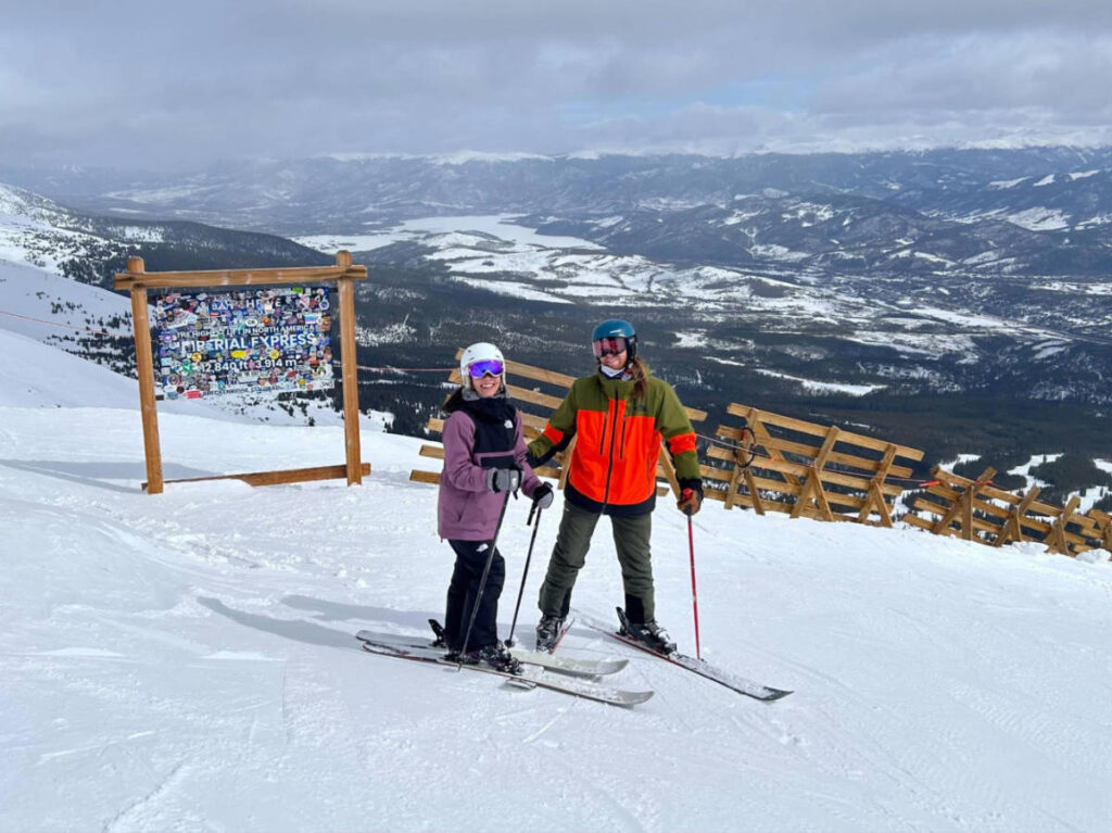 Travel Lemming writer Abigail Bliss and her husband, skiing with an overlooking view