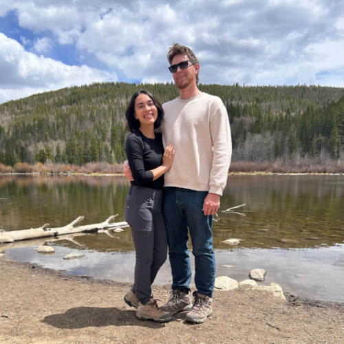 The author Abigail Bliss and her husband, posing for a photo with scenic overlooking view