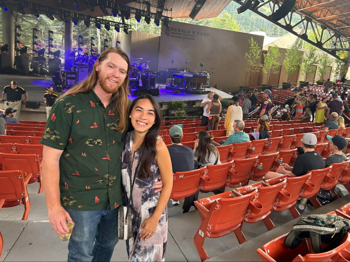 The author Abigail Bliss and her husband, smiling for a photo at the Ford Amphitheater