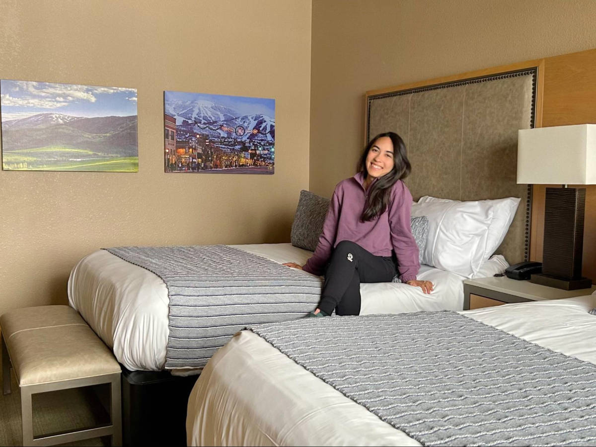 The author Abigail Bliss, sitting on the bed at The Steamboat Grand