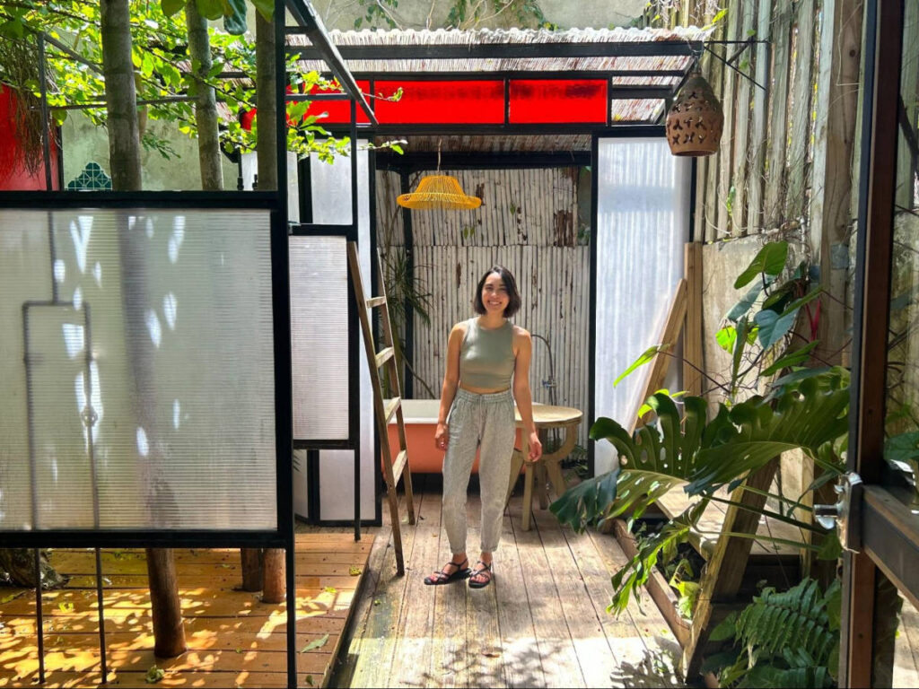 The author Abigail Bliss, wearing simple clothes at an outdoor bath area