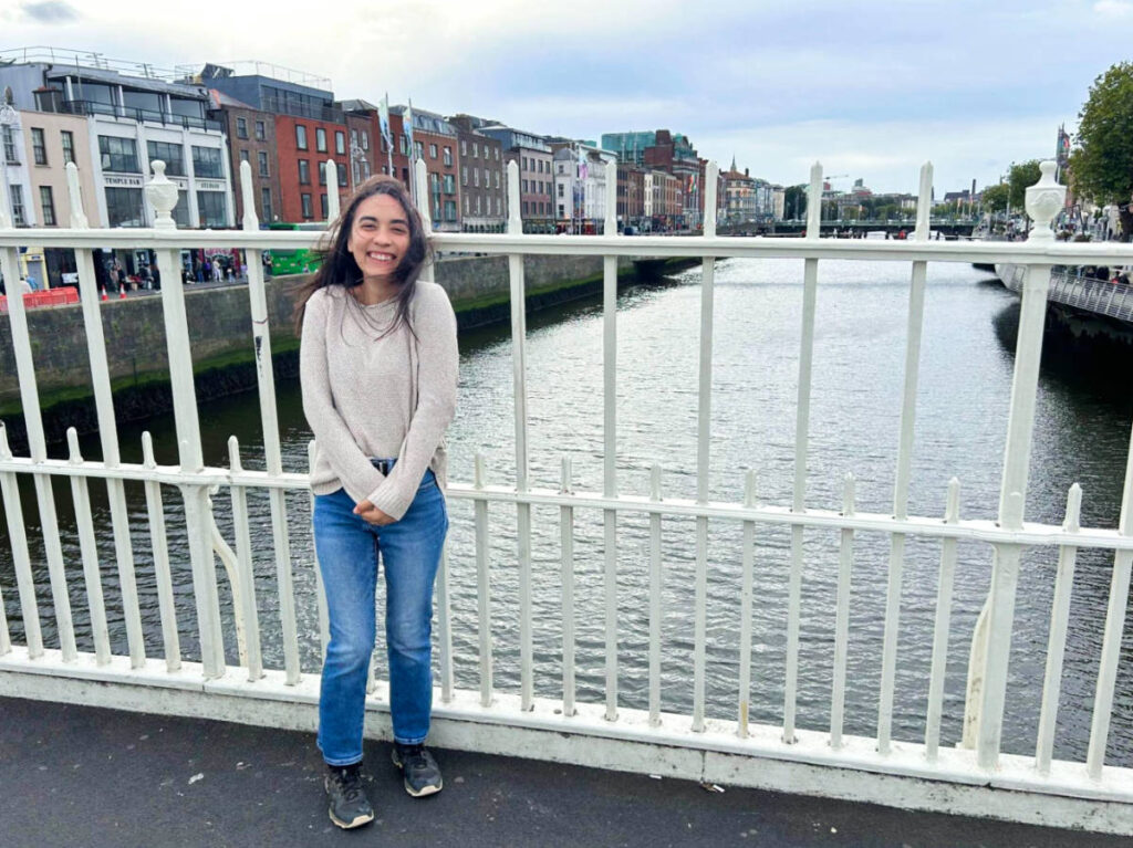 The author Abigail posing for a photo at the River Liffey on a windy day