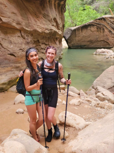 Editor Abigail and her friend hiking the Narrows at Zion National Park