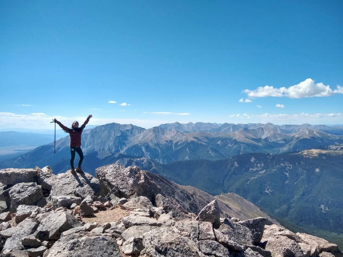 The author Abigail Bliss, posing for a photo at the summit of Mt. Yale
