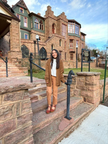 Travel Lemming Editor Abigail Bliss, standing on the staircase outside the Glen Eyrie Castle