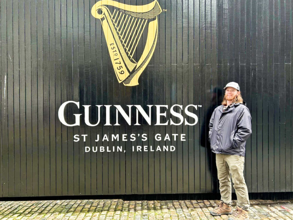 The author's husband posing for a photo in front of the Guinness Storehouse signage