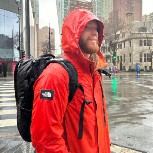 The author's husband using the Tortuga 40L Travel Backpack Lite on a rainy day