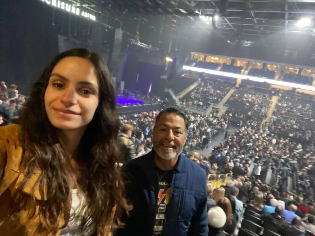 The author, McKenna Mobley with her father during a concert at the Acrisure Arena