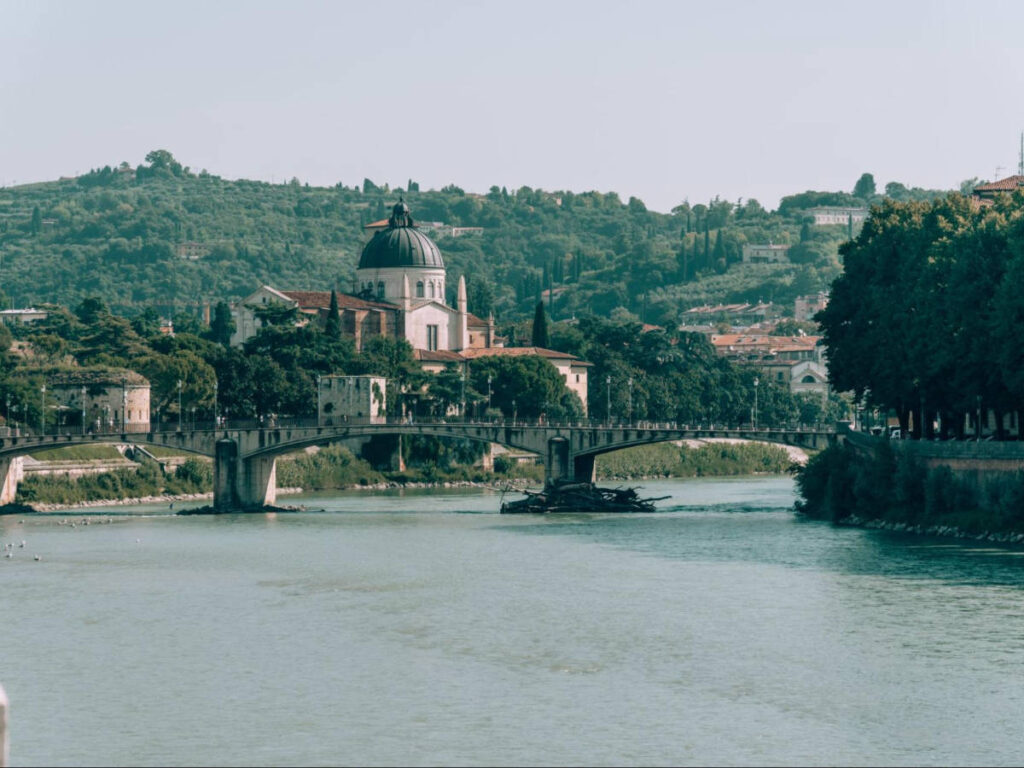 View of the serene Adige River surrounded by architecture and greeenry