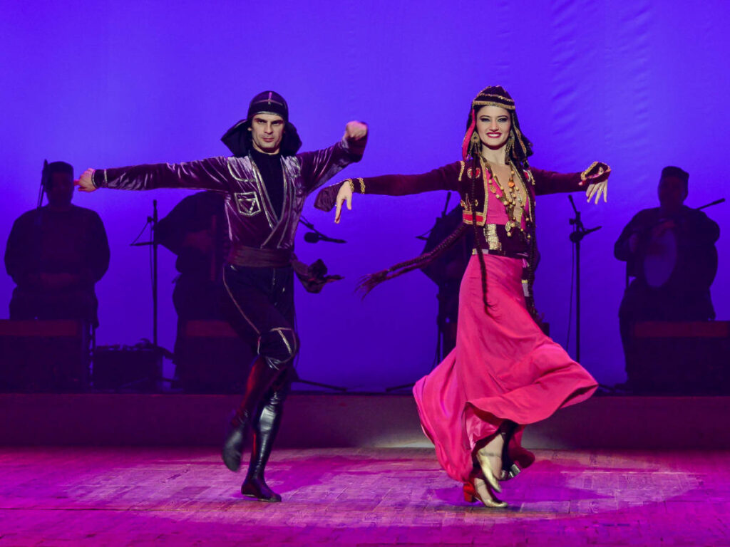 A man and a woman performing a Adjaran dance while wearing a traditional attire