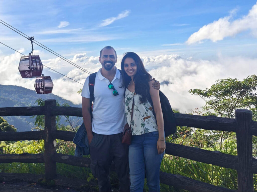 The author, Advaita and her husband, smiling for a photo at the misty highlands of Genting