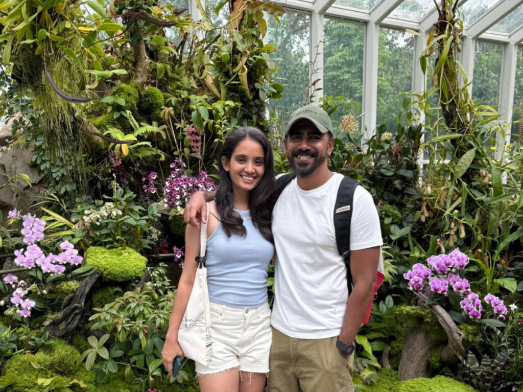 The author Advaita and her husband, smiling for a photot at the Orchid Garden in Singapore Botanic Gardens