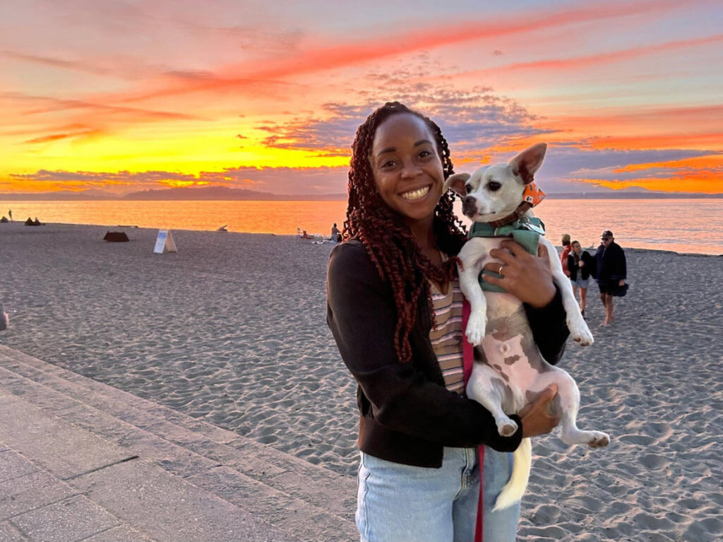 The author, Chelsea Booker with her dog at the Alki Beach during sunset