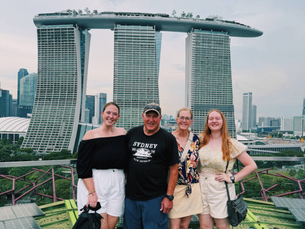 The author Allie Hubers and her family smiling for a photo with the Marina Bay Sands in the background