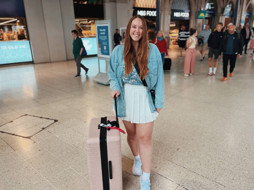 The author Allie Hubers, holding her carryon luggage at the airport