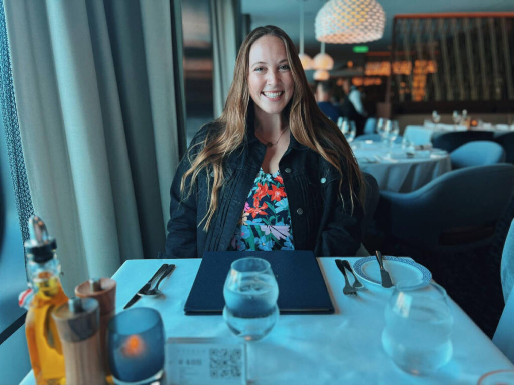 The author Allie Hubers, smiling for a photo in the restaurant of Celebrity Cruise