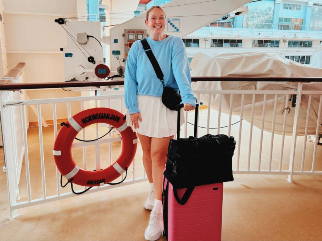 The author Allie Hubers, posing for a photo while holding her carry-on bags for embarkation
