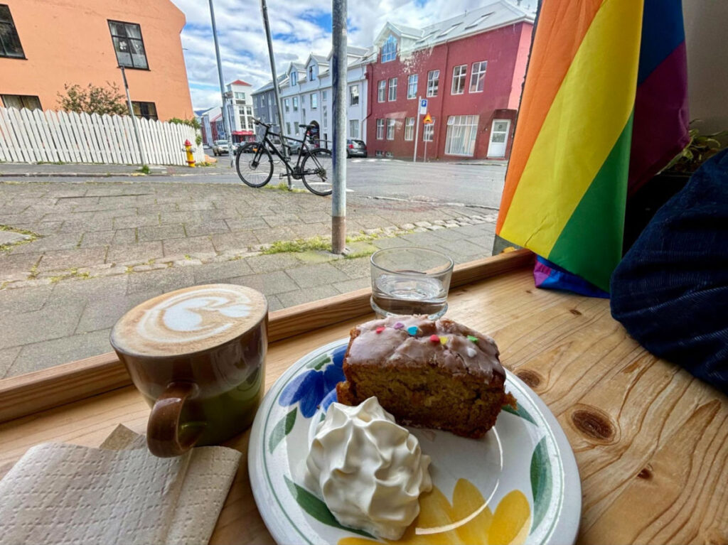 Almond cake on a plate and a glass of coffee and water