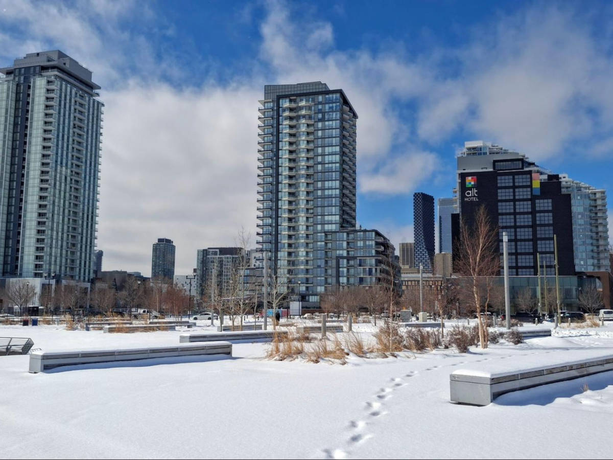 Scenic snowy view of the Alt Hotel Calgary East Village and East Village highrises from the RiverWalk