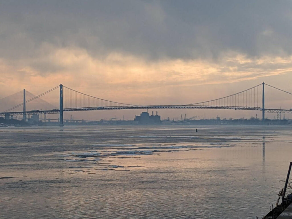 Panoramic view of the Ambassador Bridge and Detroit-Windsor Tunnel at sunset