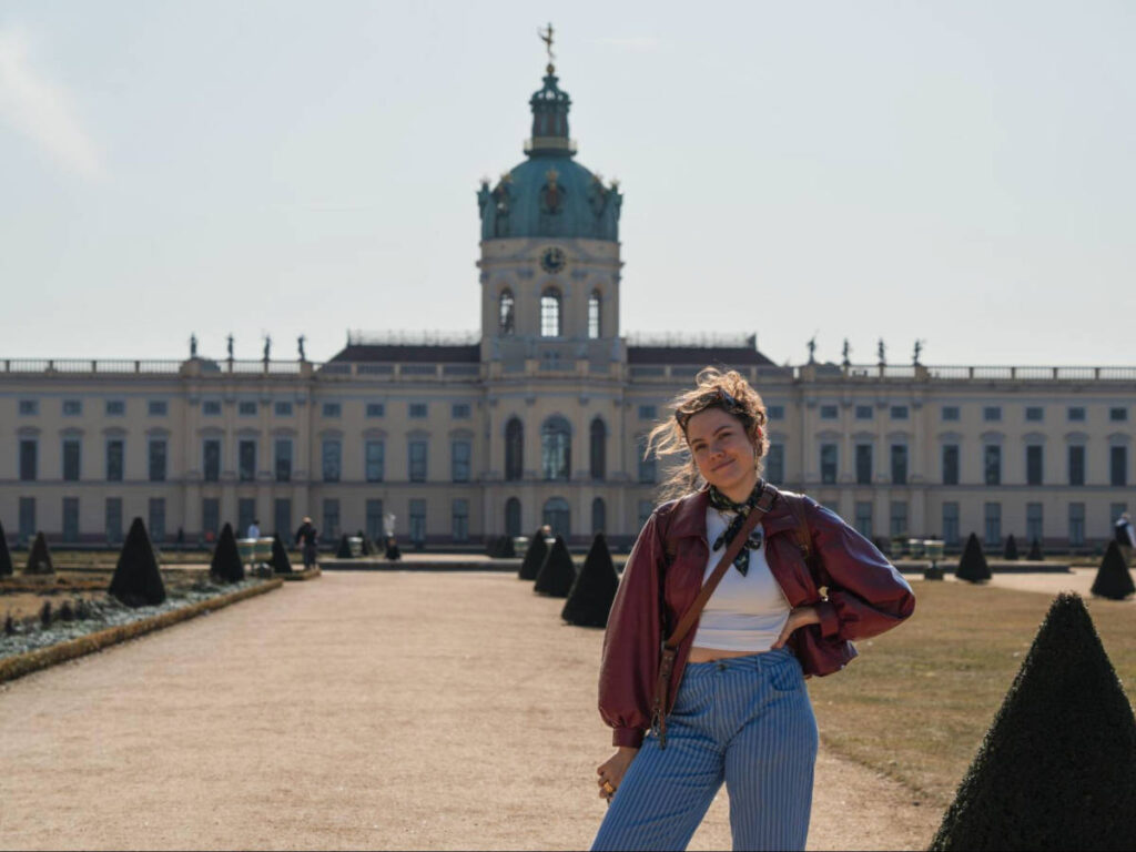 The author Amber Visch, posing for a photo with the view of the Schloss Charlottenburg