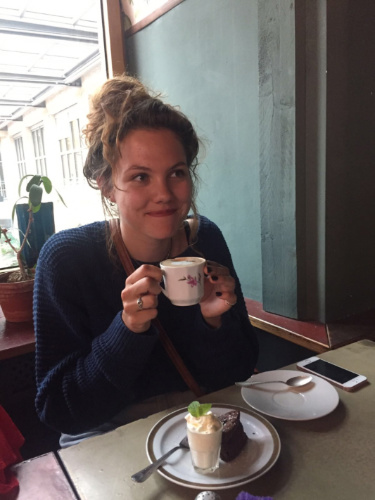 The author Amber Visch, drinking a cup of coffee at the House of Small Wonder in 2017