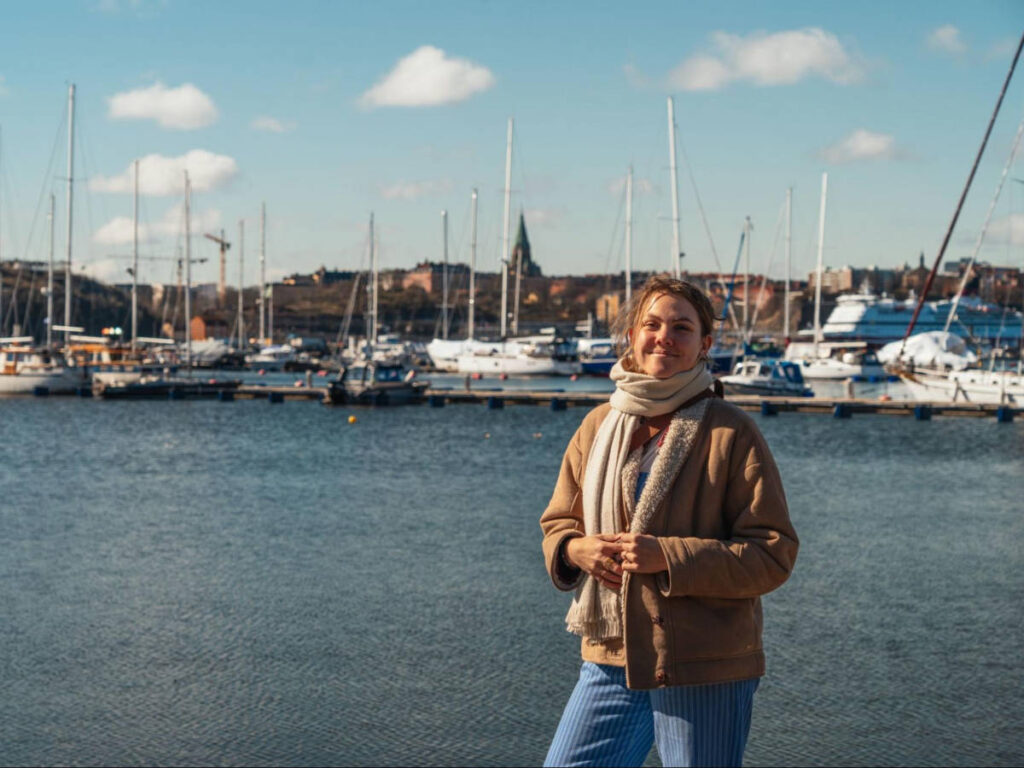 The author Amber Visch, posing for a at a marina in Djurgården