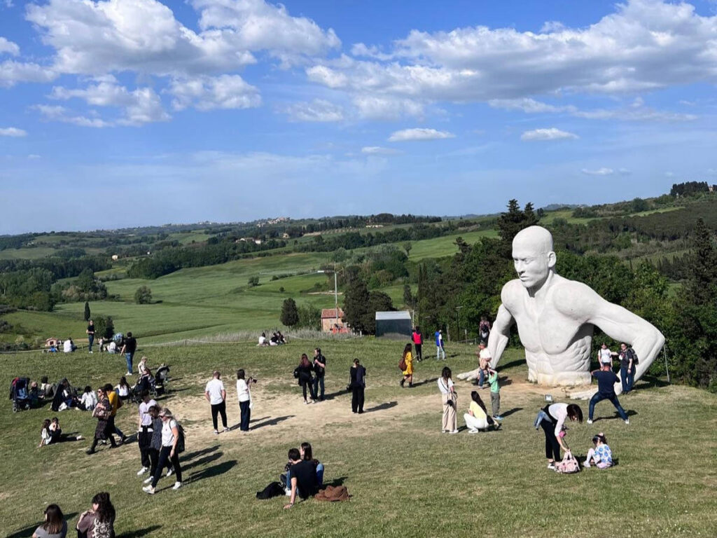 People admiring the Peccioli Giants in Anfiteatro di Fonte Mazzola