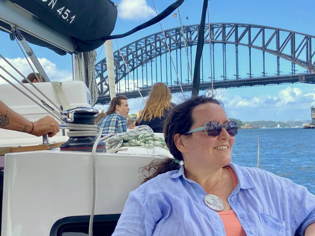 The author Ann-Marie Cahill, enjoying under the Sydney Harbour Bridge from the chartered yacht