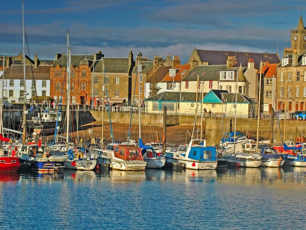 Boats docked and buildings seen on Anstruther Fishing village