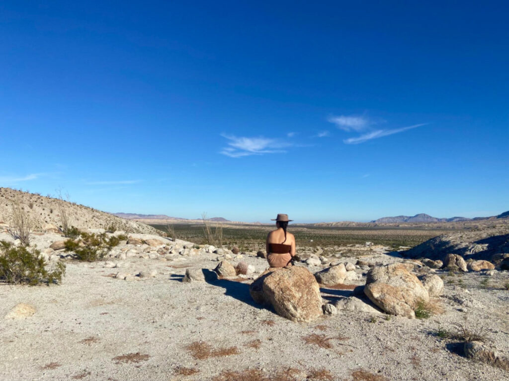 A woman sitting on a desert rock at Anza Borrego Desert State Park