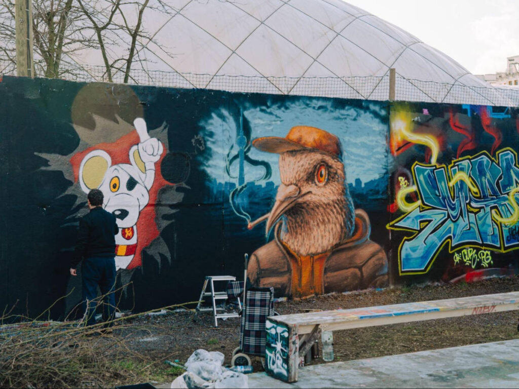 An artist working on a mural at the North Side Gallery