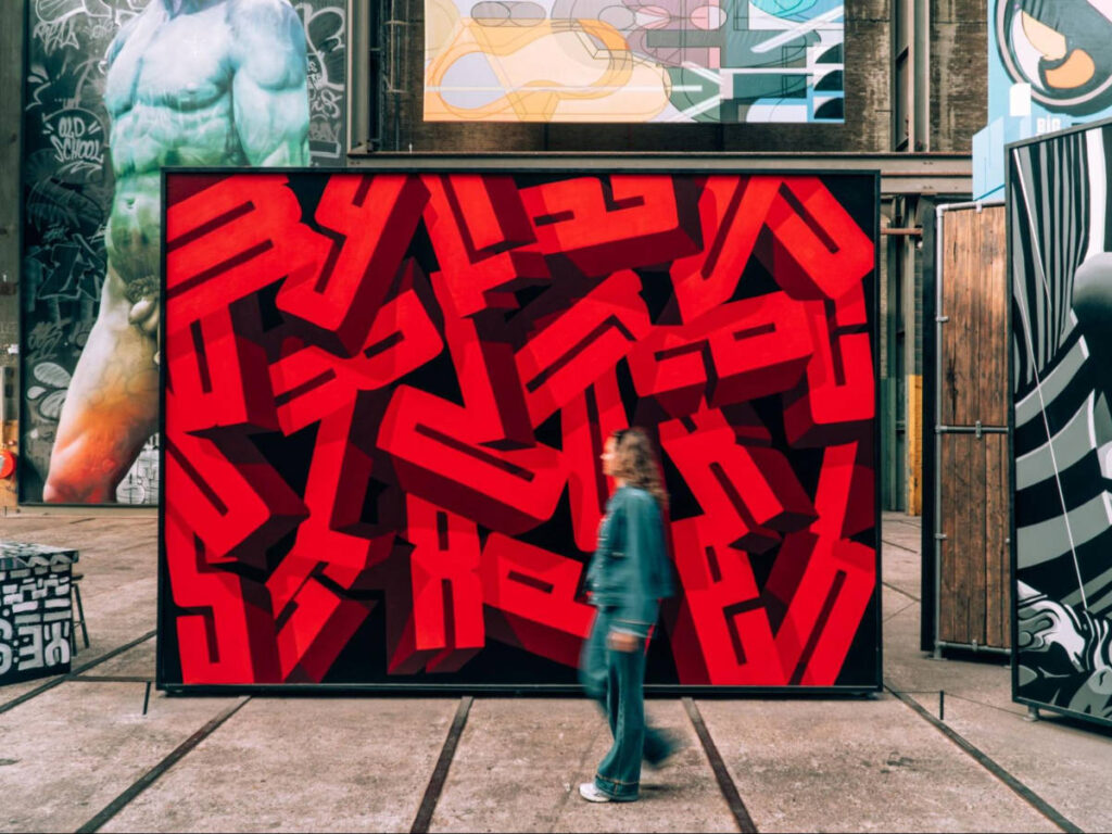 A woman walking in front of the huge artwork in Straat