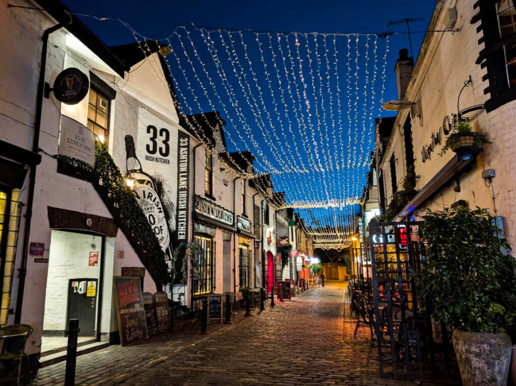 The illuminated stringed lights above the Ashton Lane at night