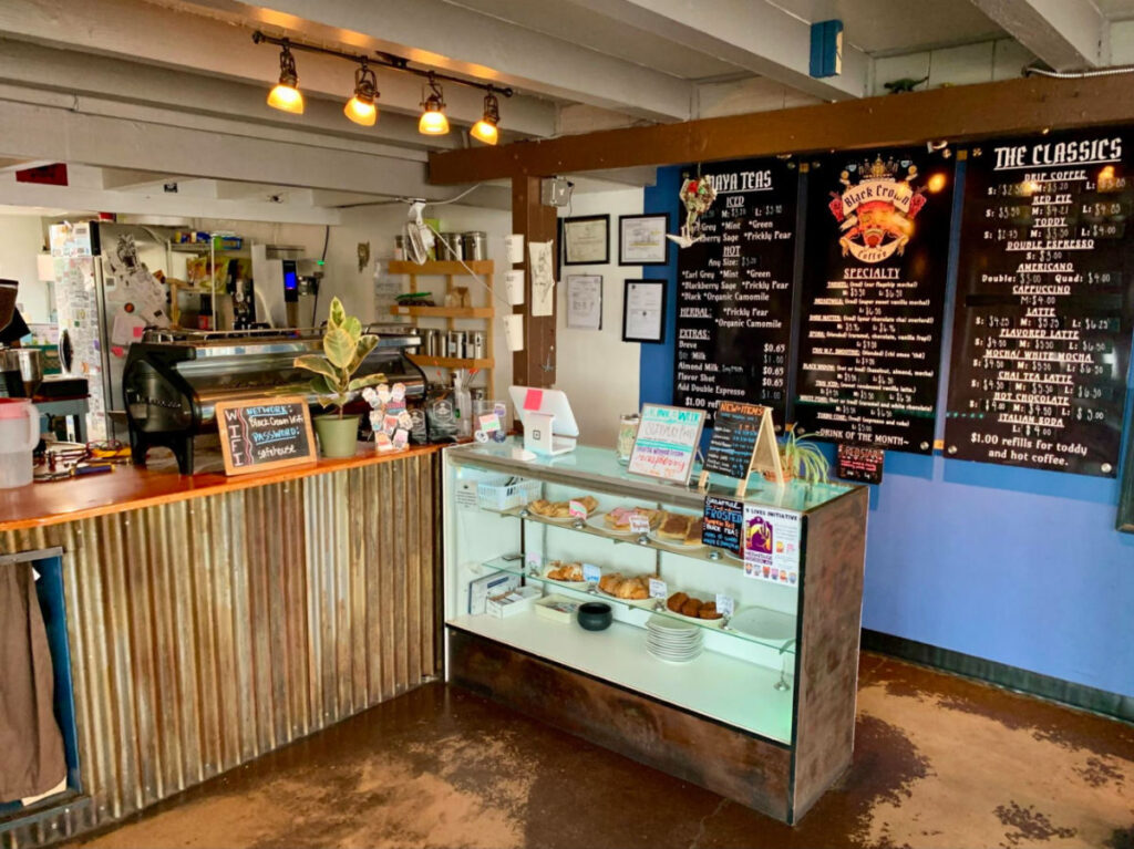 Interior of Black Crown Coffee Company showing the menu and cake displays