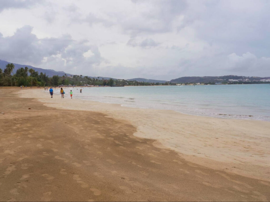 People walking along the coastline of Luquillo Beach