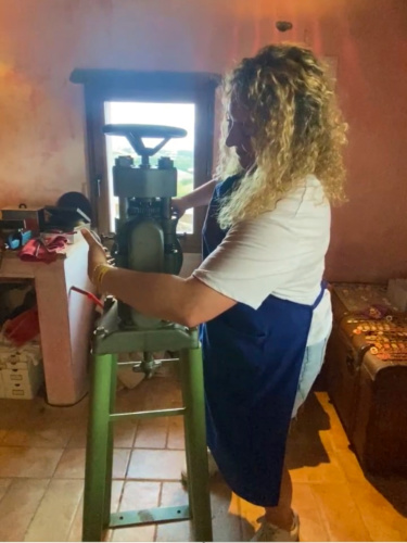 Author Jess operating a machine to create souvenirs in Schmuck Studio in San Casciano, Italy