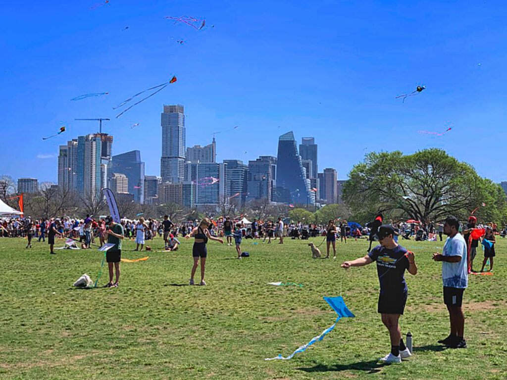 People flying their kites at Zilker Park during the Austin Kite Festival