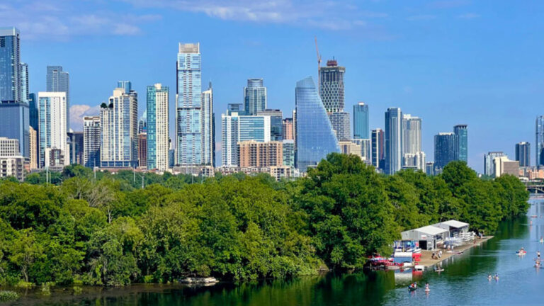 Panoramic view of the Austin skyline surrounded by greenery in summer