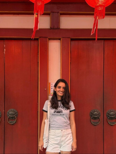 Author Advaita standing infront of the vermillion doors of the Buddha Tooth Relic Temple in Chinatown