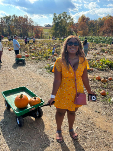 Author Alexandria holding a wagon filled with pumpkins at Baugher’s Orchard