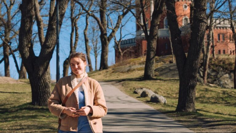Author Amber standing on a tree-lined path on Skeppsholmen island in Stockholm