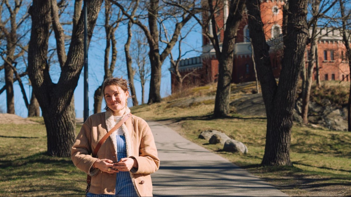 Author Amber standing on a tree-lined path on Skeppsholmen island in Stockholm
